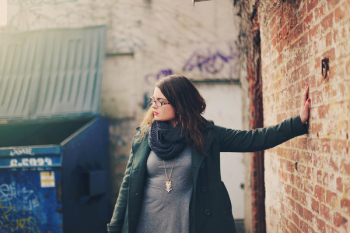 Woman Wearing Green Coat Leaning Left Hand on Wall Woman Wearing Green Coat Leaning Left Hand on Wall