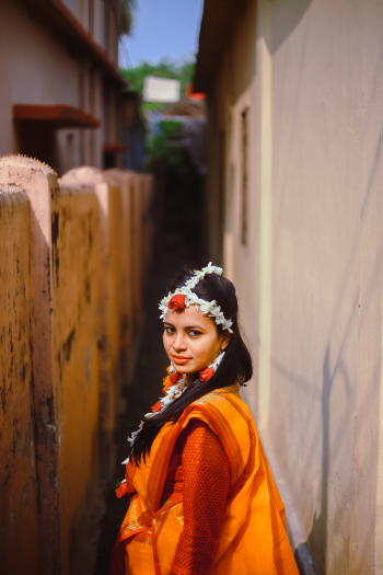 Woman Wearing Orange Tradition Costume Standing on Pathway While Glancing Her Left Side