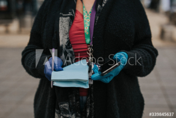 Woman wearing protective latex gloves and holding a phone. BRISTOL, UK, March 30, 2020