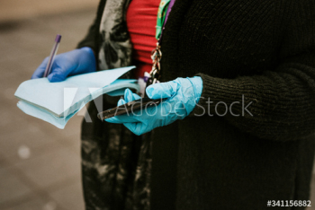 Woman wearing protective latex gloves and holding a phone. BRISTOL, UK, March 30, 2020