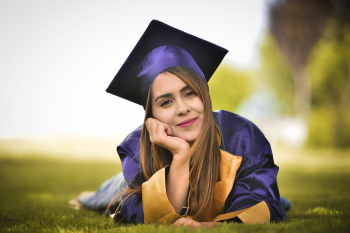 Woman Wearing Purple Graduation Gown Lying on Field Woman Wearing Purple Graduation Gown Lying on Field