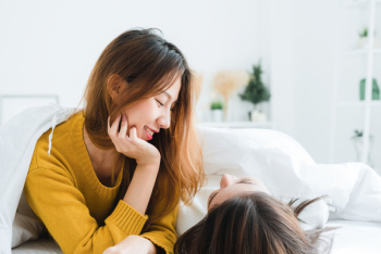 Woman Wearing Sweatshirt Lying on White Mattress Woman Wearing Sweatshirt Lying on White Mattress