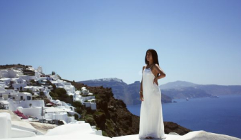 woman wearing white dress in front building beside sea woman wearing white dress in front building beside sea