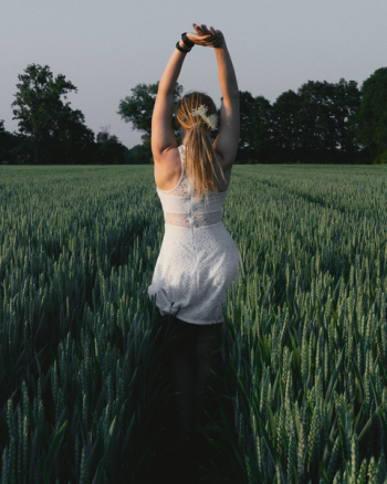Woman Wearing White Lace Dress With Hands Raised Above Head