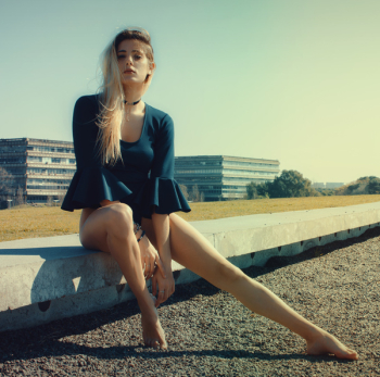 Woman Wears Black Scoop-neck Long-sleeved Blouse Seats on Grey Concrete Pavement