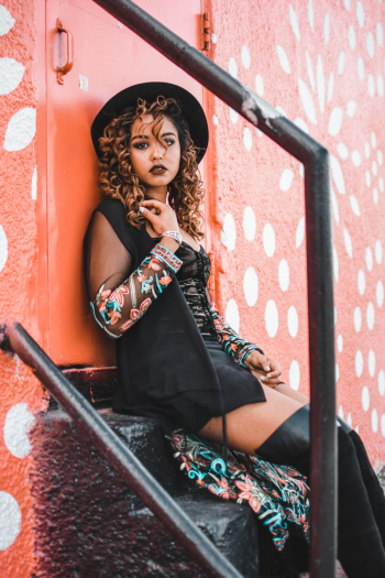 Woman With Curly Hair Sitting Down on Steps Woman With Curly Hair Sitting Down on Steps
