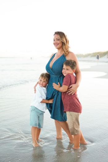 woman with two child hugging talking photo on beach shore