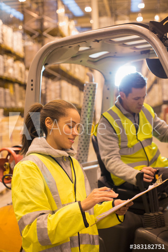 Workers at forklift in distribution warehouse Workers at forklift in distribution warehouse