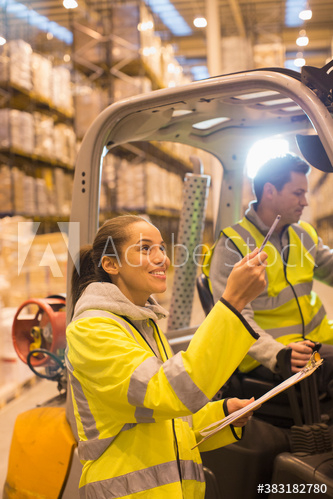Workers talking at forklift in distribution warehouse Workers talking at forklift in distribution warehouse