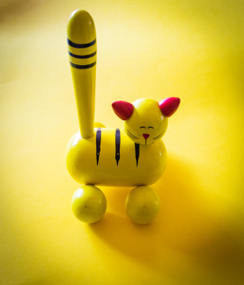 Yellow and Red Cat Figurine on Yellow Top