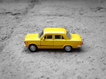 yellow sedan die-cast on gravel yellow sedan die-cast on gravel