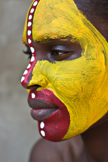 Young African girl, tribal painted face in yellow and red