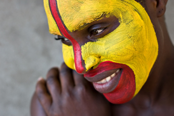 Young African girl, tribal painted face in yellow and red