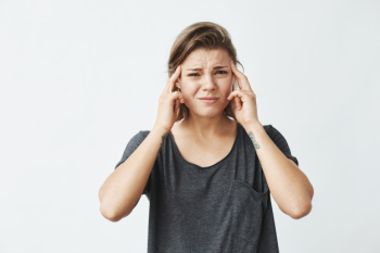 Young beautiful girl frowning with fingers on temples . Free Photo Young beautiful girl frowning with fingers on temples . Free Photo