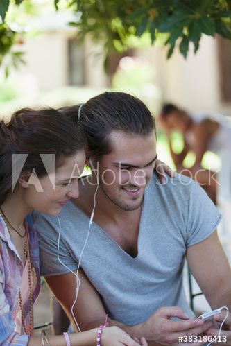 Young couple sharing headphones listening to music Young couple sharing headphones listening to music