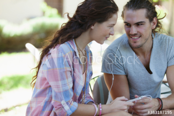 Young couple sharing headphones listening to music Young couple sharing headphones listening to music