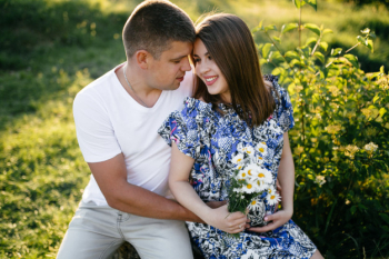 young happy beautiful couple in love walking together on grass and trees park landscape