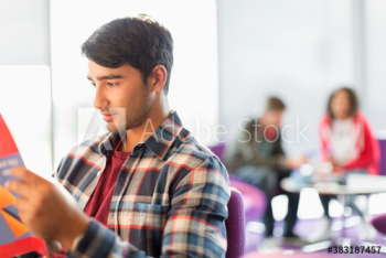Young male college student studying in student lounge Young male college student studying in student lounge