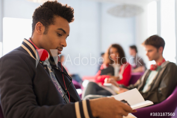 Young male college student studying in student lounge Young male college student studying in student lounge