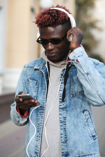 Young male on street listening music Free Photo