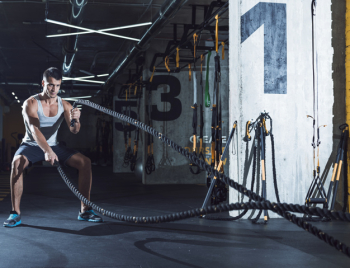 Young man exercising with battle ropes Young man exercising with battle ropes
