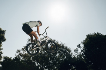 Young man jumping with bicycle up high Free Photo