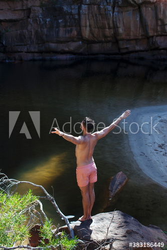 Young man preparing to dive off rocks Young man preparing to dive off rocks