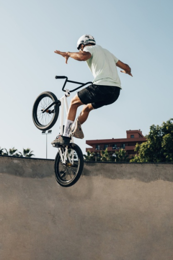 Young man riding on a bmx bicycle in skatepark Free Photo