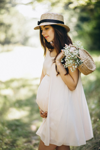 Young pregnant woman in park