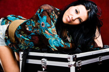 young woman leaned on big suitcase, studio shot