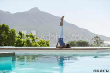 Young woman practicing yoga supported shoulderstand at sunny poolside Young woman practicing yoga supported shoulderstand at sunny poolside
