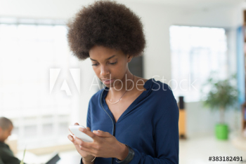 Young woman with afro texting with smart phone Young woman with afro texting with smart phone