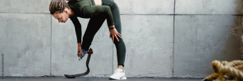 Young woman with prosthesis doing exercise during yoga practice