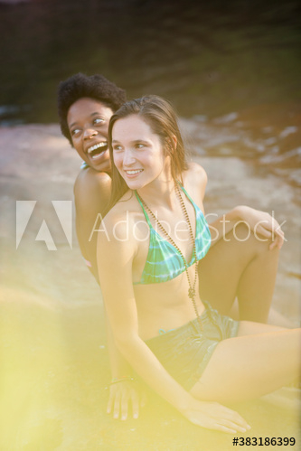 Young women friends in bathing suits at lakeside Young women friends in bathing suits at lakeside
