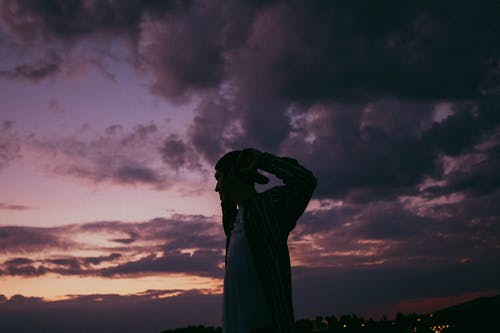 A Man Wearing Cap Standing Under Evening Sky · Free Stock Photo