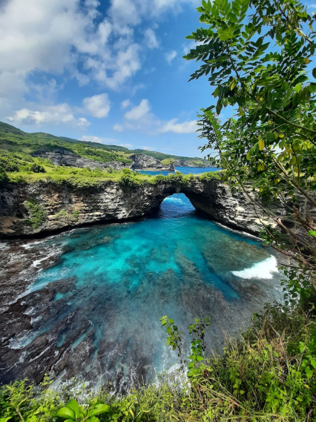 A Rock Formation Near the Body of Water Under the Blue Sky