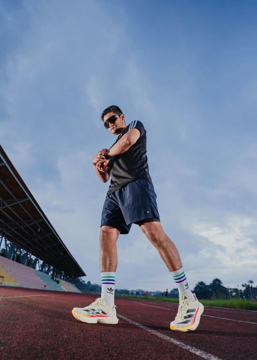 Athletic Male Runner Preparing for Race on Track