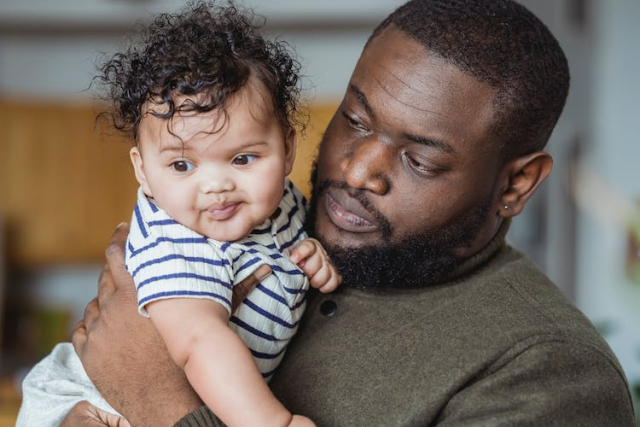 Black father carrying adorable little baby