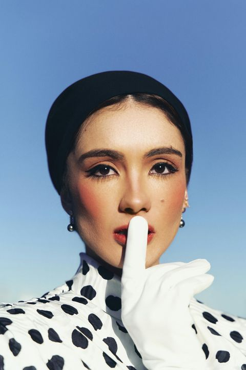 Elegant Woman in Polka Dot Fashion with a Quiet Gesture