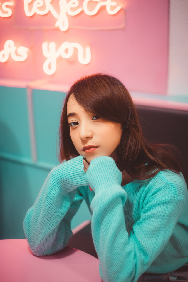 Girl in Sweater Sitting in Front of Table