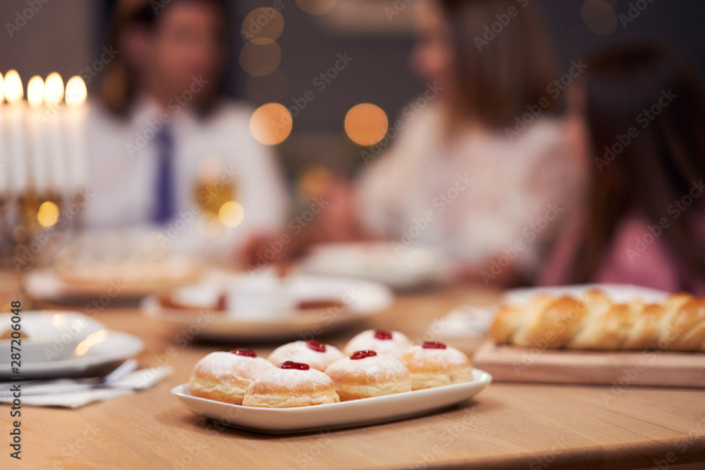 Hanukkah dinner. Family gathered around the table with traditional dishes