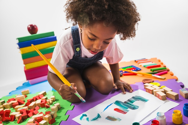 Kid drawing on play mat in studio