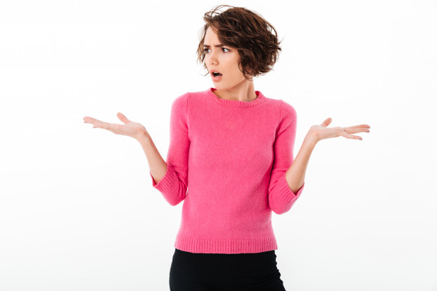 Portrait of a puzzled young girl shrugging shoulders Free Photo