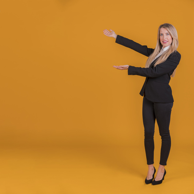 Portrait of a young businesswoman giving presentation against an orange background Free Photo