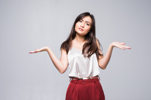 Smiling asian woman showing copy space for product isolated on white wall. Free Photo