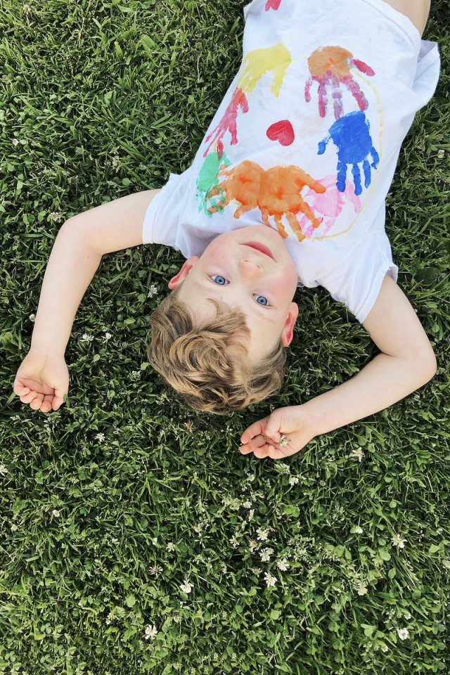 Smiling kindergarten boy lying down on the grass | Free Photo - rawpixel