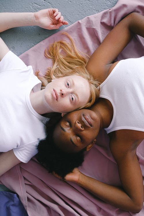 Two Women Lying Together on the Floor · Free Stock Photo