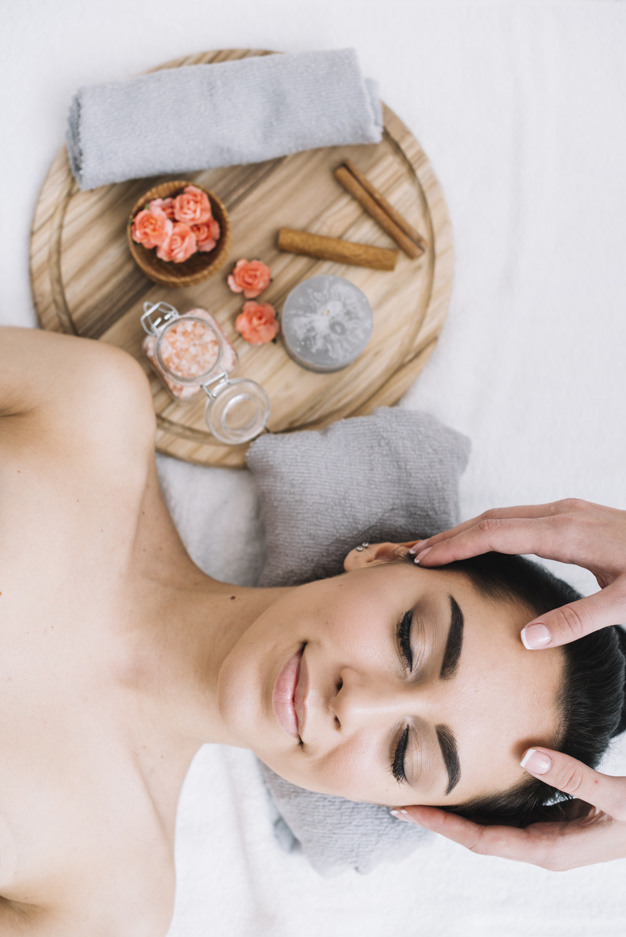 Woman receiving a relaxing facial massage Free Photo
