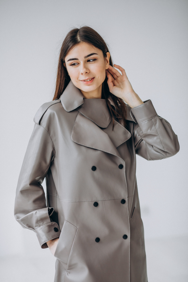 Young woman wearing a leather trench-coat